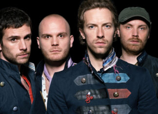 The Coldplay band members posing together in dark vintage jackets