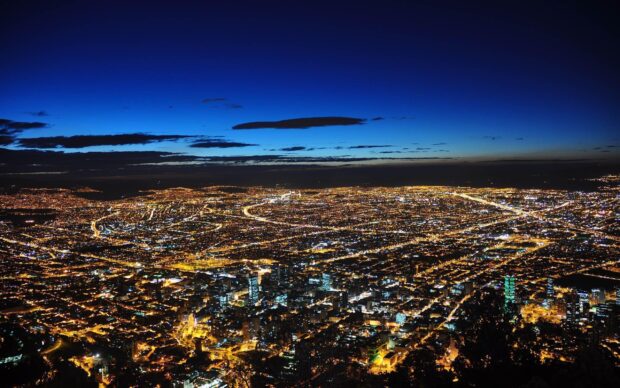 Night aerial view of Colombia cityscape with glowing lights and dark blue sky