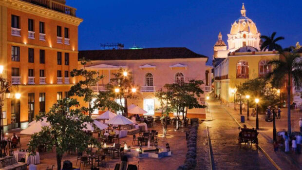 Historic Colombia street scene with colonial architecture and outdoor dining area at dusk