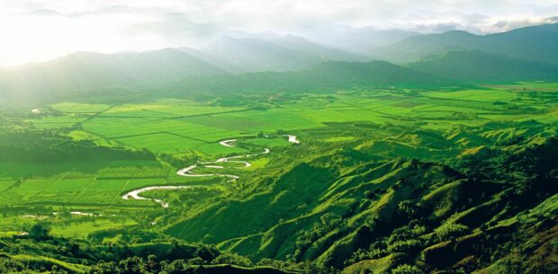 Lush green landscape with winding river and agricultural fields in Colombia