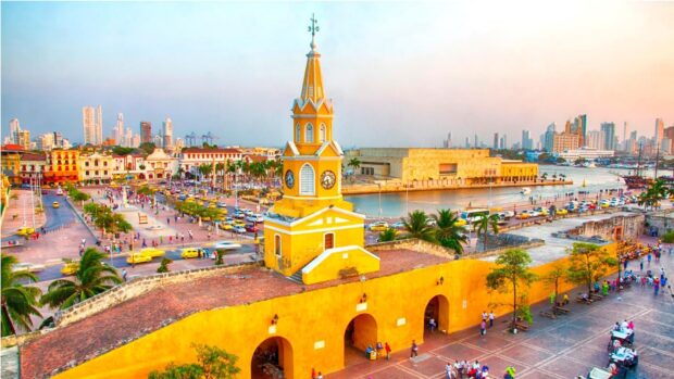 Historic clock tower in Colombia cityscape with colorful buildings and waterfront view