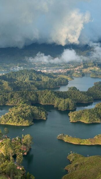 Lush green hills of Colombia surrounded by calm rivers and misty clouds