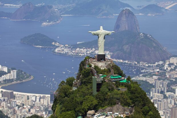 A panoramic view of Corcovado Mountain with the iconic statue overlooking the city and ocean