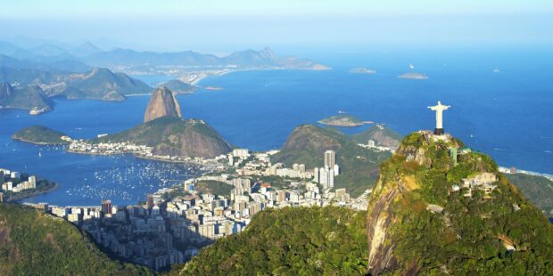 A panoramic view of Corcovado Mountain with the statue overlooking Rio de Janeiro and the ocean bay