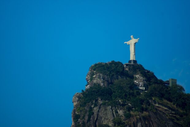 The Corcovado Mountain with the iconic statue on top under a clear blue sky