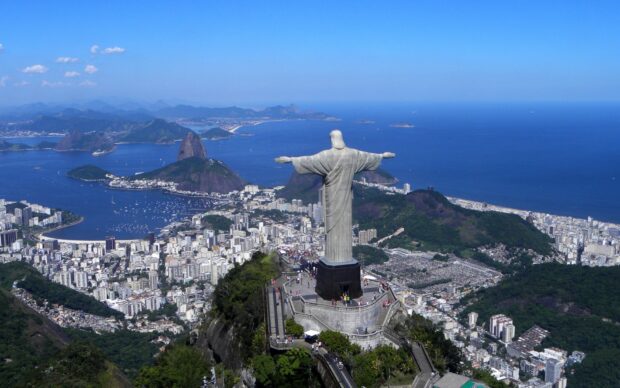A panoramic view of Corcovado Mountain overlooking the cityscape and ocean bay