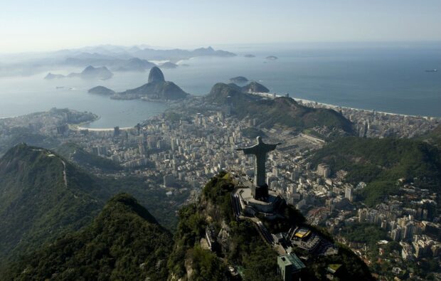 A stunning view of Corcovado Mountain overlooking the cityscape and ocean bay in HD quality
