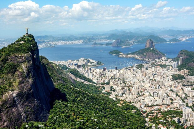 Corcovado Mountain overlooks the cityscape and coastline with lush greenery