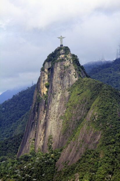 Corcovado Mountain with lush greenery and the Christ statue on top in clear weather