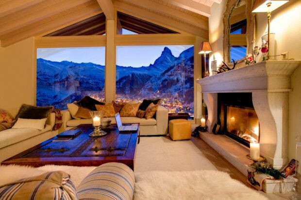 Cozy winter living room with mountain view and warm fireplace in the background
