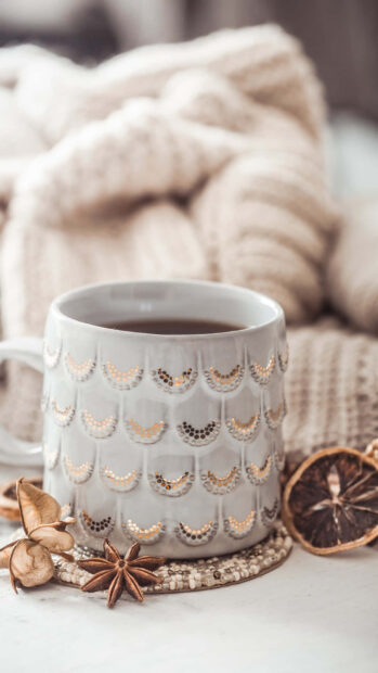 Warm and cozy knitwear with hot drink and star anise spices on table