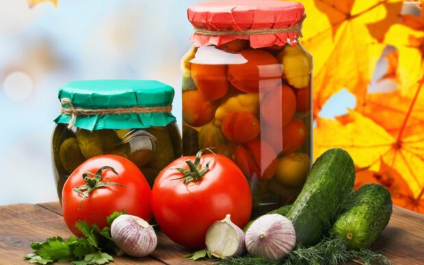 Fresh cucumbers and tomatoes with garlic on a wooden surface