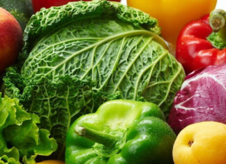 Fresh cucumber surrounded by various fresh vegetables and fruits in vibrant colors