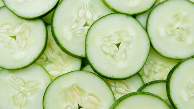 Close up of fresh cucumber slices showing seeds and green skin texture