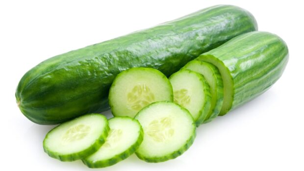Fresh cucumber slices with whole cucumber on white surface