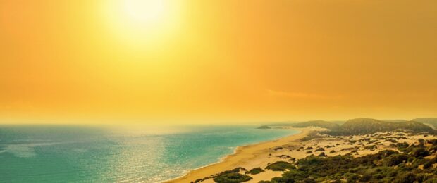 Golden sunset over the Cyprus coastline with sandy beaches and Mediterranean Sea viewed from above