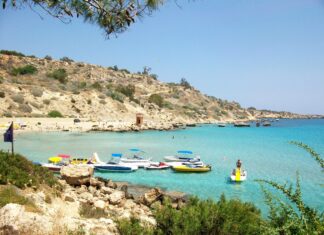 Cyprus Wallpapers 2K Desktop A scenic view of Cyprus coastline with clear turquoise water and boats anchored near the rocky shore