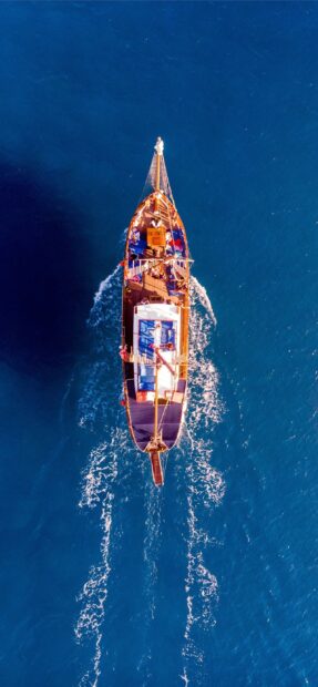 Aerial view of a traditional Cyprus boat sailing on deep blue sea