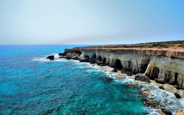 Scenic Cyprus coastline with turquoise waters and rocky cliffs under clear sky