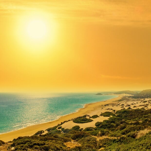Beautiful Cyprus coastline with golden sands and clear blue sea under bright sunlight
