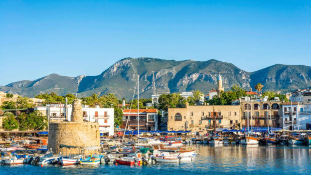 Historic harbor and castle in Cyprus with mountains in the background