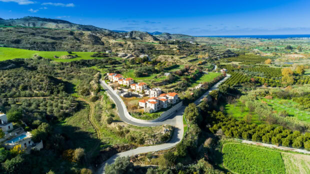 A scenic view of Cyprus village surrounded by lush green hills and winding roads in vibrant nature
