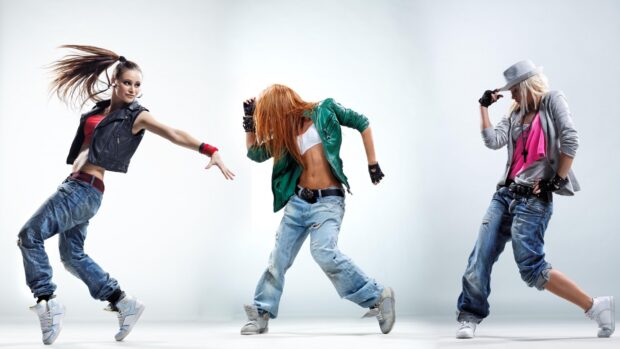 Three dancers performing urban dance moves in stylish casual clothing