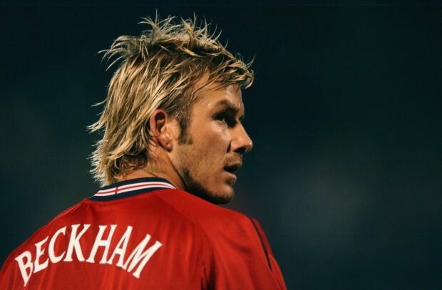 David Beckham wearing red sportswear looking focused during a match