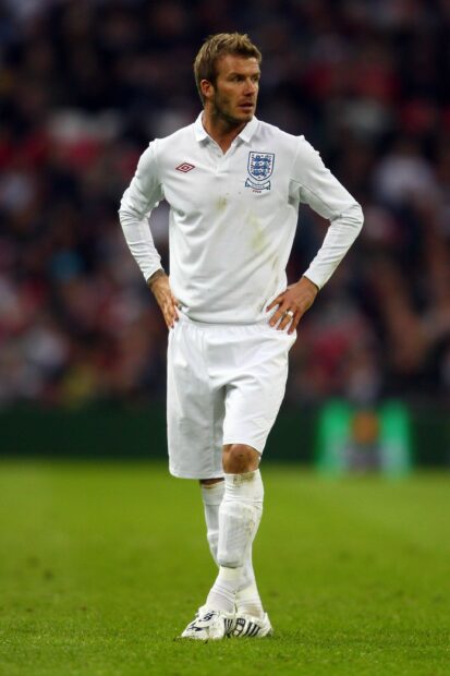 David Beckham standing on the soccer field wearing an England jersey during the match