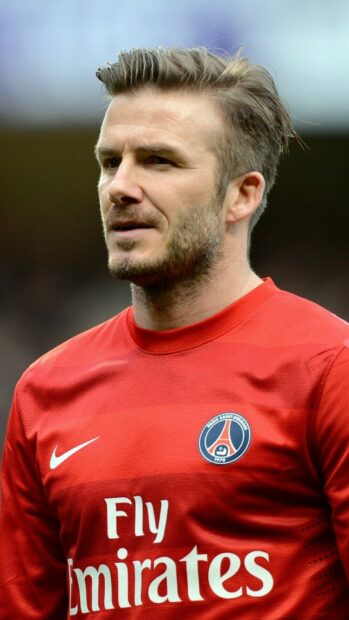 David Beckham wearing a red Paris Saint Germain jersey during a football match