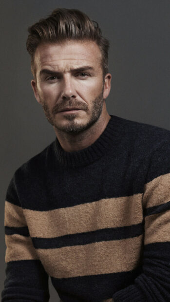 David Beckham wearing a striped sweater looking serious in a closeup portrait