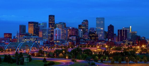 Nighttime cityscape of Denver Colorado with illuminated buildings and highways