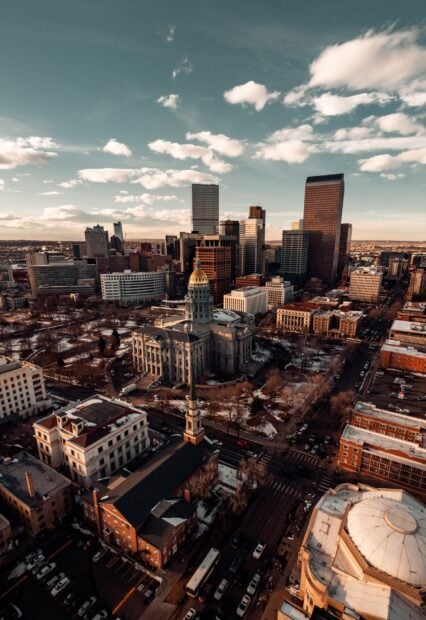Aerial view of Denver cityscape with the state capitol building under a partly cloudy sky