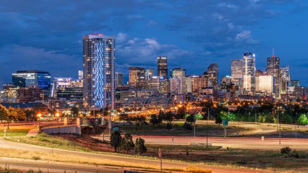 Denver Colorado skyline at dusk showing modern skyscrapers and highways