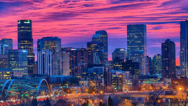 Denver Colorado cityscape with colorful sunset sky and illuminated buildings