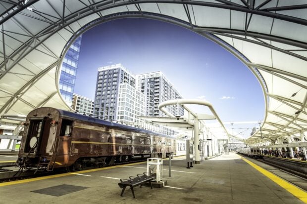 Vintage train at the Denver Colorado station with modern buildings in the background