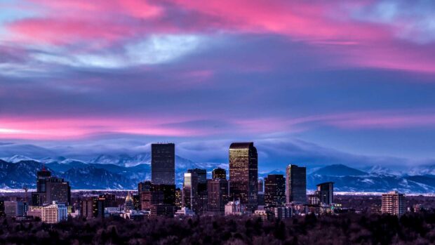 Denver city skyline with mountains in the background during a colorful sunset sky