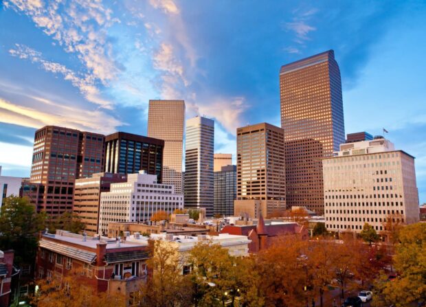Downtown Denver Colorado cityscape with autumn trees and skyscrapers at sunset