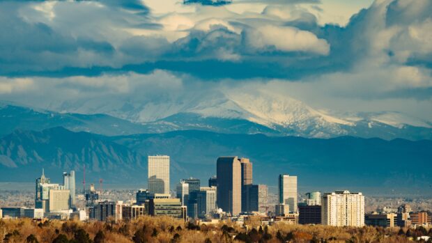 Denver skyline with snowy mountains under dramatic clouds in high resolution