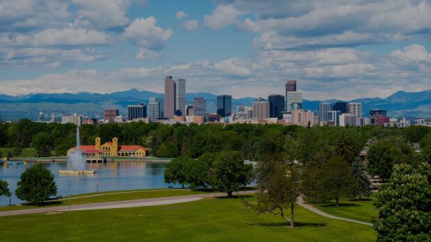 Downtown Denver skyline with greenery and mountains in the background