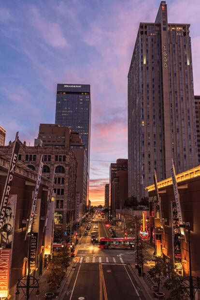 Denver city skyline with tall buildings and a street view at sunset