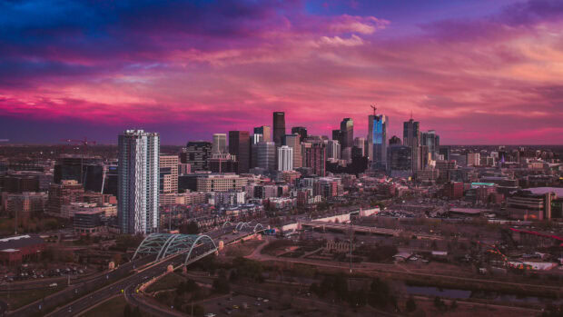 Denver skyline captured under a vibrant sunset with colorful clouds and city buildings