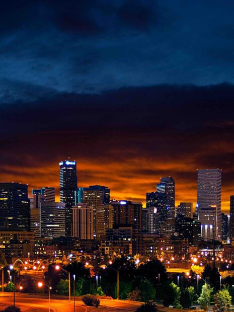 Denver skyline with glowing city lights under a vibrant evening sky