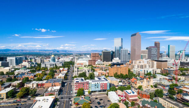 A clear view of Denver skyline with skyscrapers and mountains in the background