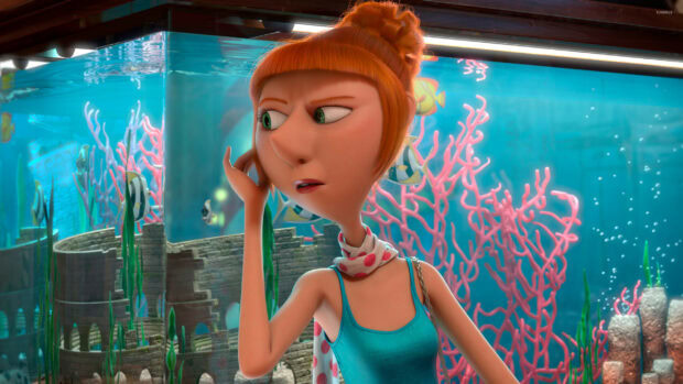 A Despicable Me character with orange hair looks concerned near an aquarium with colorful coral and fish