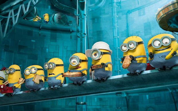 Minions from Despicable Me holding sandwiches while standing on a metallic beam in a futuristic factory setting