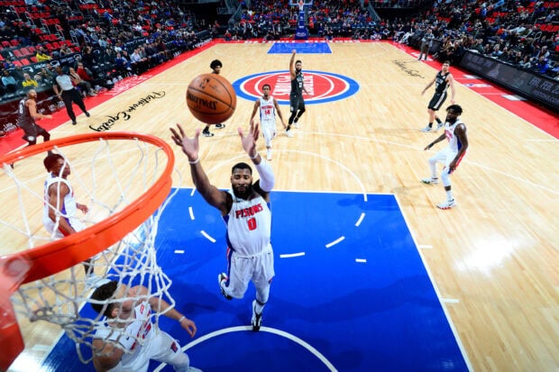 Detroit Pistons player jumping to score a basket during a basketball game on the court