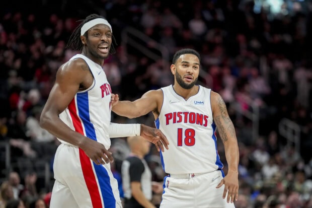 Two Detroit Pistons players celebrating on basketball court during game