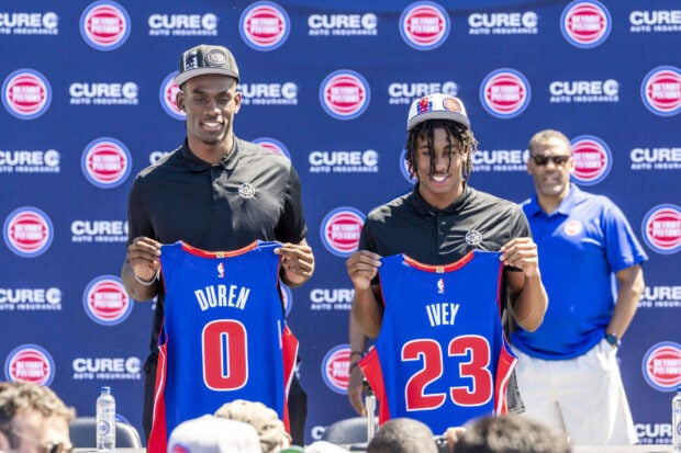 Two Detroit Pistons players holding jerseys with Duren and Ivey names at a press event