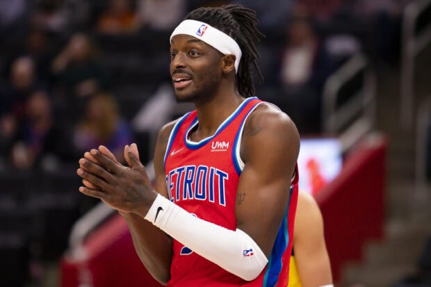 A Detroit Pistons player clapping hands during a basketball game wearing a red jersey